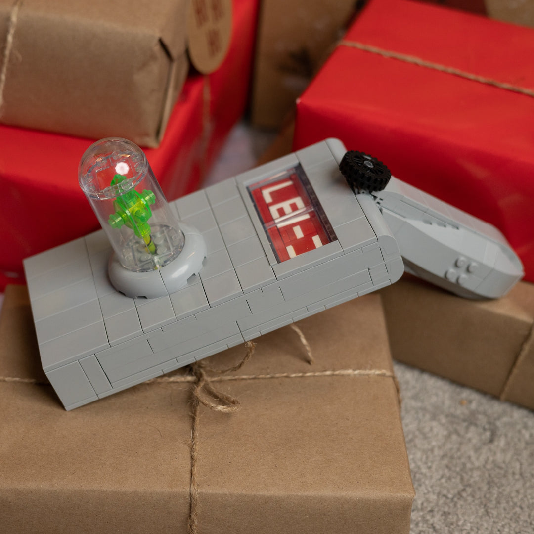 Rick's Portal Gun Life-Sized Replica built with LEGO® bricks - by Bricker Builds surrounded by gifts