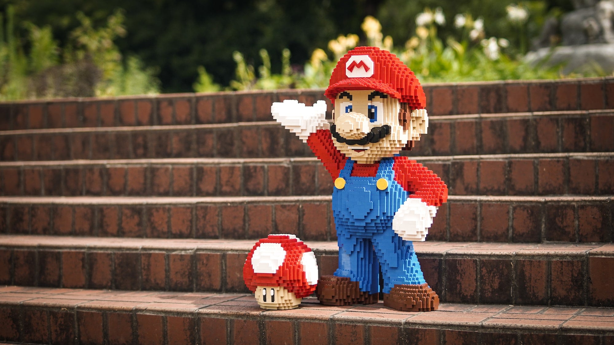 bricker builds lego mario build on steps next to lego toad build