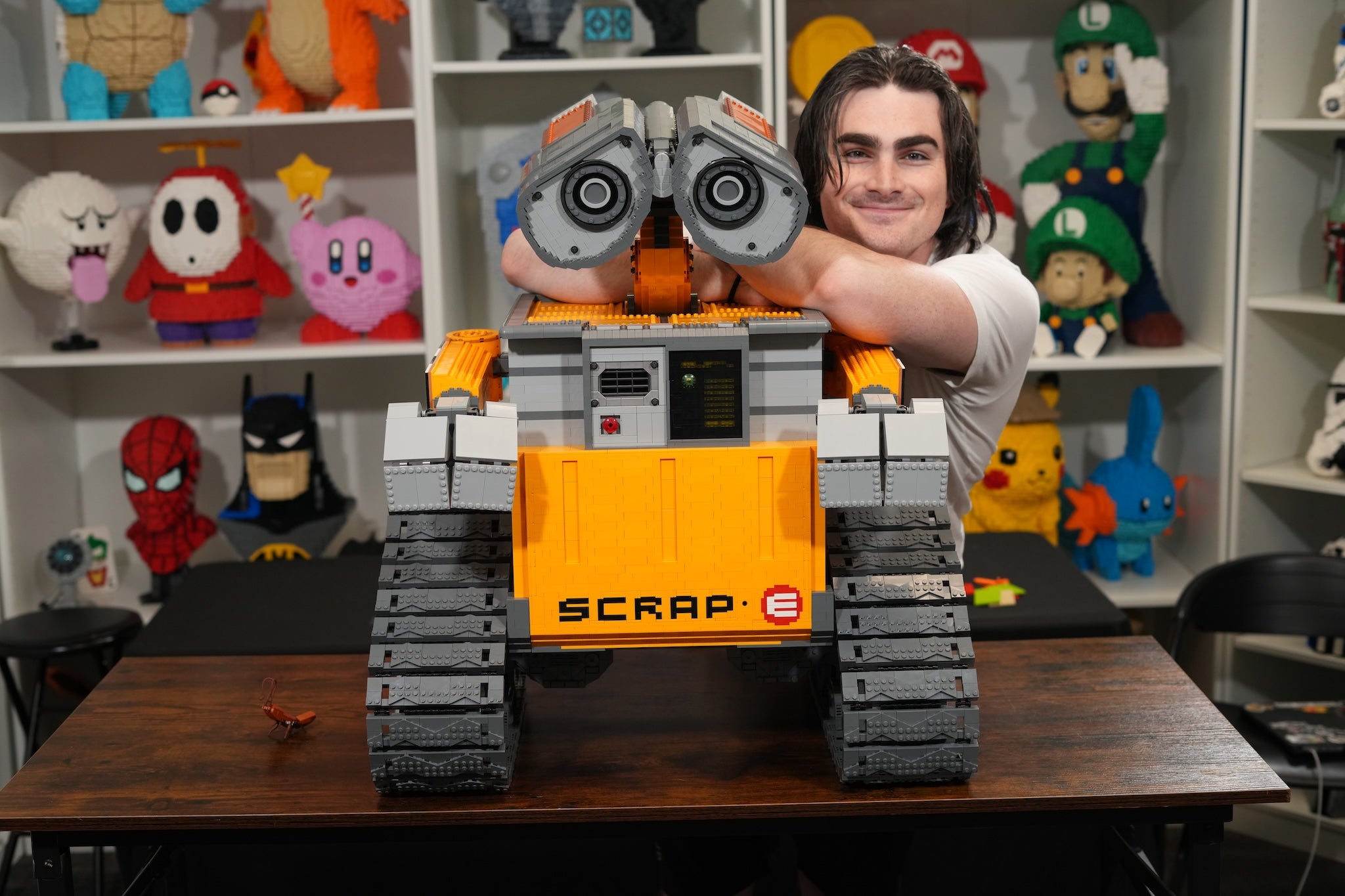 SCRAP-E premium LEGO® brick custom display model designed by Bricker Builds with designer Tyler featuring articulated arms, movable head, opening compartment, and custom lighting.